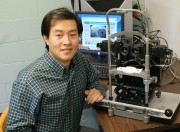 Dr Fan Xiaofei Fan, a post-doctoral fellow at MU, sits next to the computerized binocular infrared pulillography device, a machine that measures the time that the eye takes to react to a flash of light.